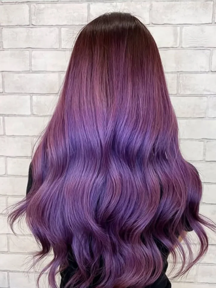 Long hair coloured a deep burgundy-to-purple ombre, seen from behind