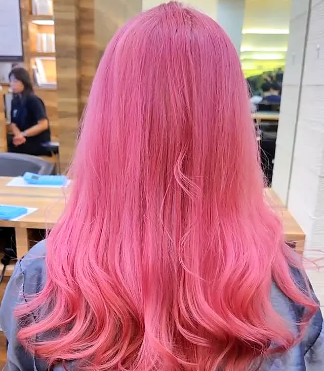 A full pink colour through long layered hair, photographed in the salon after finishing