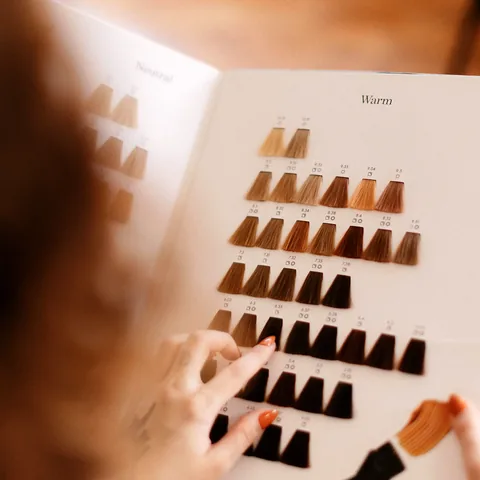 A colour swatch book open on a page of warm brown shades