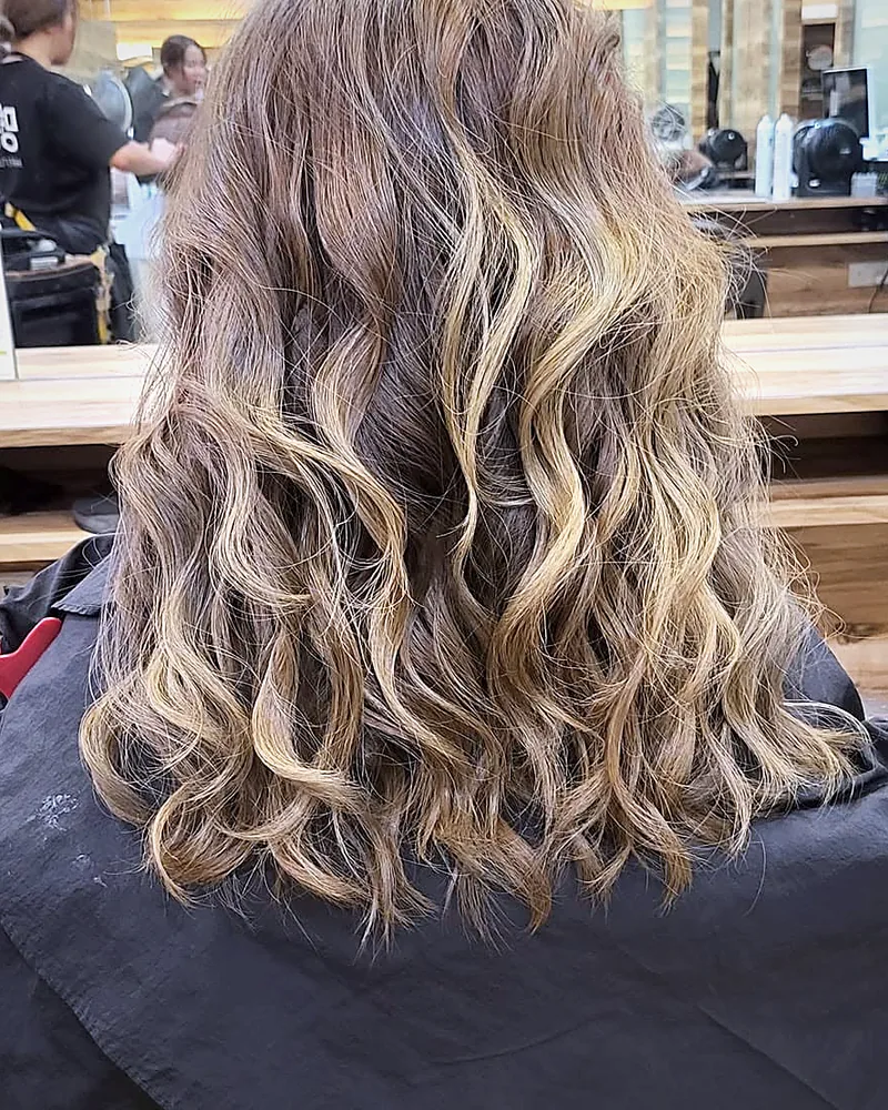 Blonde balayage on textured mid-length waves
