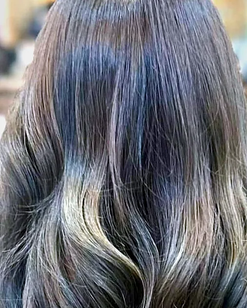 Face-framing blonde highlights through dark wavy hair